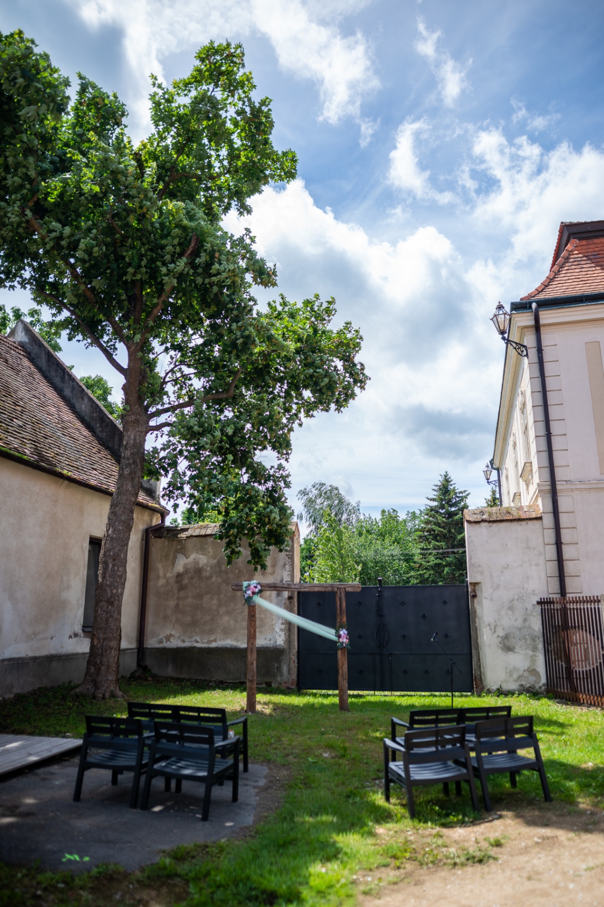 Zámecký dvůr s obřadním obloukem a vzrostlým stromem